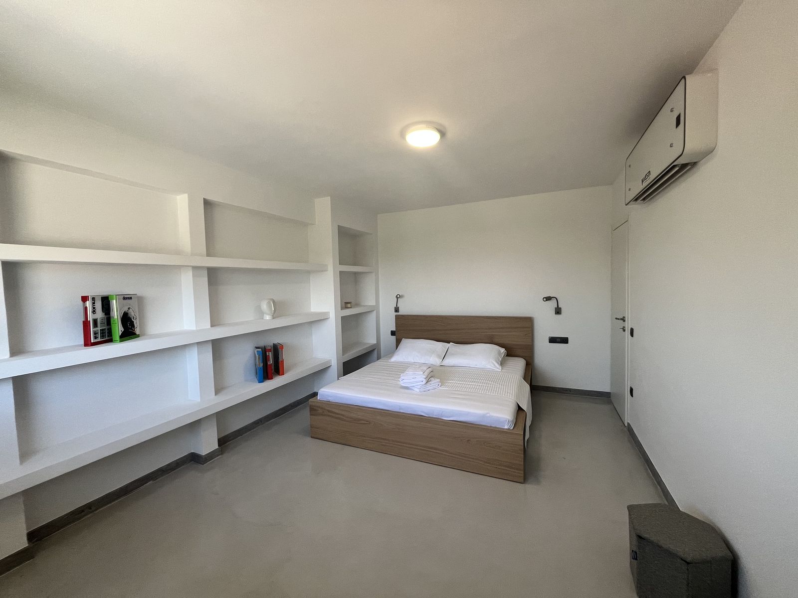 The master bedroom, with a double bed and a wall of built-in shelving.