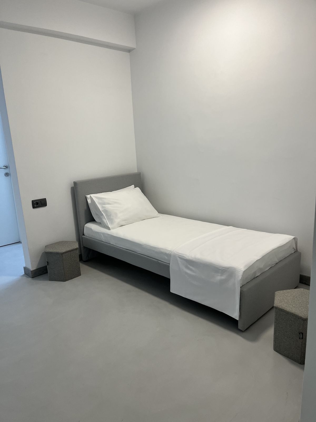 The second bedroom, with a single bed and calm, pared-back finish.
