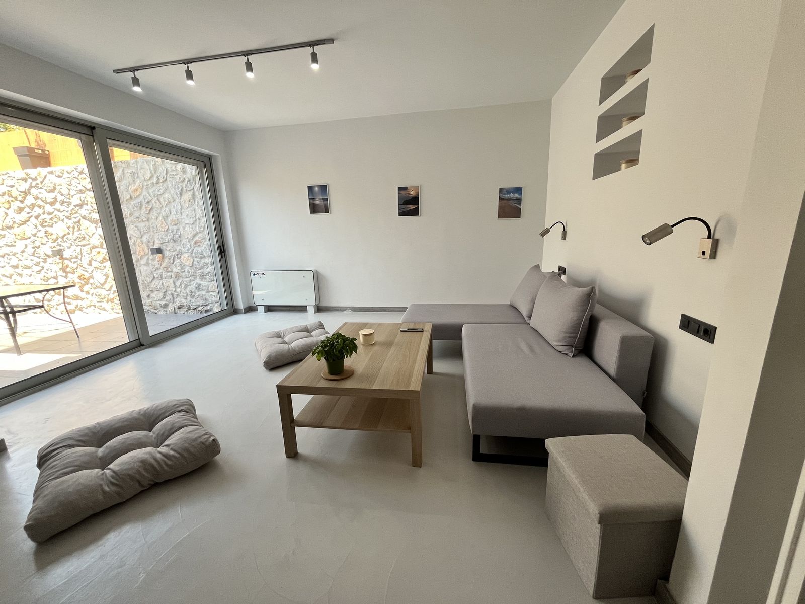 The open-plan living room, opening through glass to the courtyard.