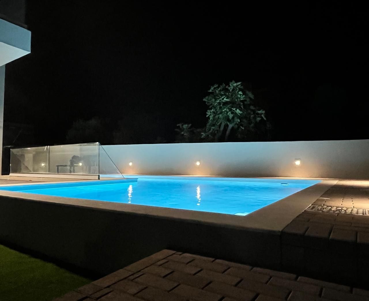 The shared pool lit blue after dark.