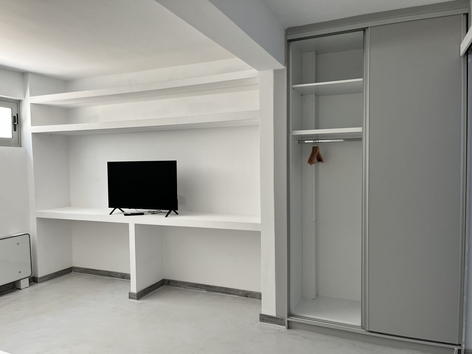 The study — a built-in desk and TV beside a fitted wardrobe.