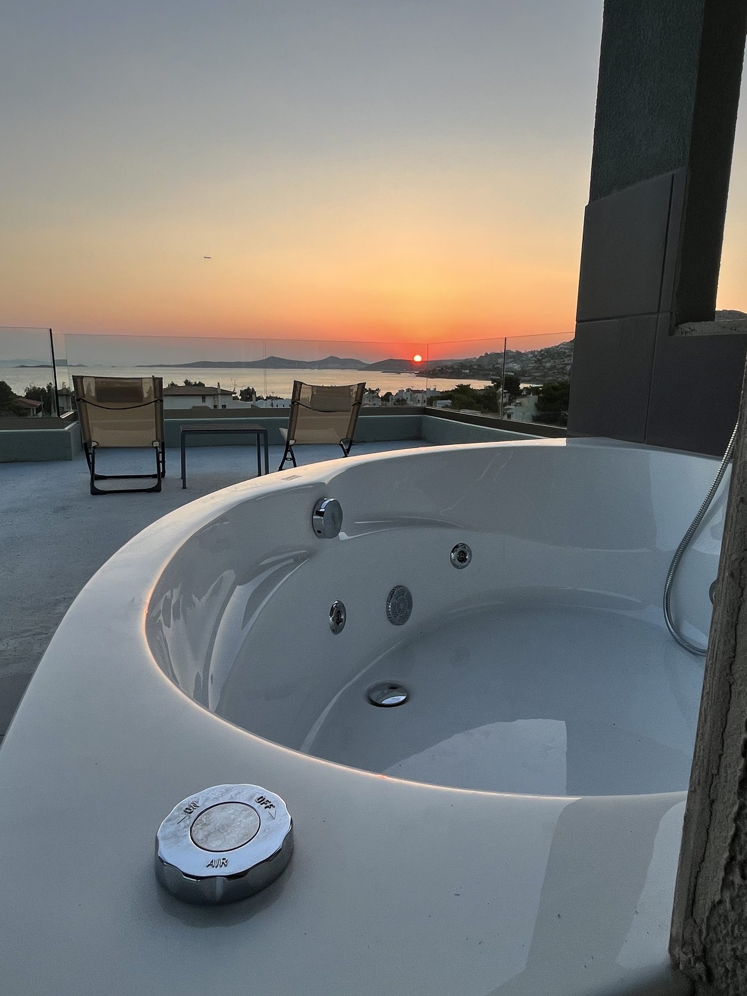 The rooftop jacuzzi at Blue Bay Dream A at sunset, looking out over the Saronic Gulf.
